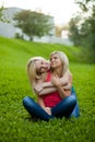 Two girls sitting on the grass, embracing Royalty Free Stock Photo