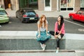 Two girls sitting near parking place