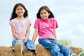 Two girls sitting on top of haybale Royalty Free Stock Photo