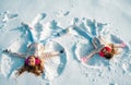 Two Girls on a snow angel shows. Children playing and making a snow angel in the snow. Top view. Royalty Free Stock Photo