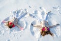 Two Girls on a snow angel shows. Children playing and making a snow angel in the snow. Top view. Royalty Free Stock Photo