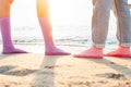 two girls stand on the beach in socks on their bare feet. close-up at sunrise. Royalty Free Stock Photo