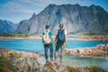 Two girls stand holding hands on the background of the Lofoten Islands, traveling to Norway, Scandinavia northern Europe Royalty Free Stock Photo