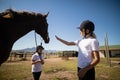 Two girls standing with a horse in the ranch Royalty Free Stock Photo