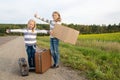 Two girls with suitcase standing about road Royalty Free Stock Photo