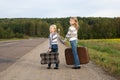 Two girls with suitcase standing about road Royalty Free Stock Photo