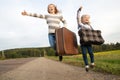 Two girls with suitcase standing about road Royalty Free Stock Photo