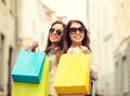 Two girls in sunglasses with shopping bags in ctiy Royalty Free Stock Photo