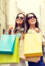 Two girls in sunglasses with shopping bags in ctiy Royalty Free Stock Photo