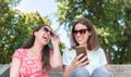 Two girls surprise social media unexpected youth millennial friendship media concept addiction to new technology trends lifestyle. Royalty Free Stock Photo