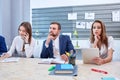 Two girls, talking on the phone and working behind the tablet, and the man looks into the distance. Royalty Free Stock Photo