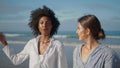 Two girls talking sea shore closeup. Carefree lesbian couple walking ocean coast