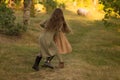 Two girls, teenagers, holding hands, walk on green grass, run in nature