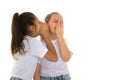 Two cheerful little girls share secrets in each other s ear. Royalty Free Stock Photo