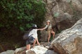 Two girls of a tourist`s girlfriend climb the mountains, help each other, reach out a helping hand. Royalty Free Stock Photo