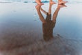 Two girls walk along the shore of the beach at sunset