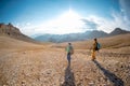 two girls on a walk in the mountains. girls with backpacks walk along a mountain path against the sky Royalty Free Stock Photo