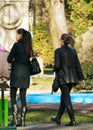 Two girls walk through the park in early spring.