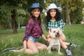 Two girls walking with his dog. cowboy hat and Royalty Free Stock Photo