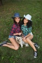 Two girls walking with his dog. cowboy hat and plaid shirt Royalty Free Stock Photo