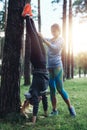 Two girls wearing sportswear training outdoors doing handstand against tree in the park