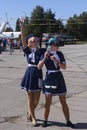 Two girls wearing stewardess uniform standing on a street in the VR glasses