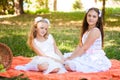 Two Girls in White Dresses Play On Orange Picnic Blanket