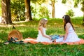 Two Girls in White dresses Read On Orange Picnic Blanket Royalty Free Stock Photo