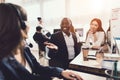 Two girls who work as operators in the call center talk to a black guy. Royalty Free Stock Photo