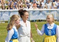 Two girls working as officals dressed in the swedish typical blue, white and yellow costume
