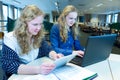 Two girls working on computer and tablet in computer classroom Royalty Free Stock Photo