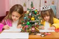 Two girls write a letter to Santa Claus