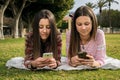 Two girls write in mobile phones