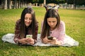 Two girls write in mobile phones