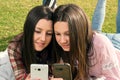 Two girls write in mobile phones