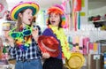 Two glad female friends choosing headdresses Royalty Free Stock Photo