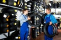 Two male professionals standing with new tires Royalty Free Stock Photo