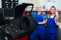 Two glad technicians working in car service