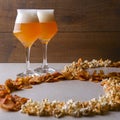 Two glass of beer and beer snacks over white background. Potato chips and popcorn shaped like an 8 Royalty Free Stock Photo