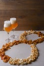 Two glass of beer and beer snacks over white background. Potato chips and popcorn shaped like an 8 Royalty Free Stock Photo