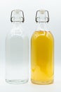 Two glass bottle containing tea and clear water Royalty Free Stock Photo