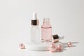 Two glass bottles of cosmetic liquid transparent gel on white background with pink pearls. Dropper bottle, hyaluronic Royalty Free Stock Photo