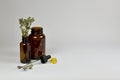 Dark glass medical bottles, dried thyme, oil capsules and a cap-pipette.