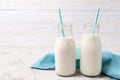 Two bottles of milk with blue straws on wooden background Royalty Free Stock Photo