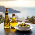 Two glass bottles of olive oil and a bowl of olives on a table over seaview landscape, copy space. Greek olive oil in glass bottle