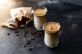 Two glass cups with Dalgona frothy coffee trend korean drink latte espresso with coffee foam on black background