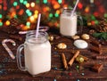 Two glass cups of hot cocoa with milk, cinnamon, candies and straw tube