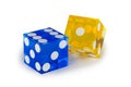 Two glass dice, blue and yellow, isolated on white, with a light shadow.