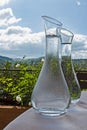 Two glass drinking water bottles on nature background. Royalty Free Stock Photo