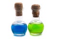 Two glass flasks with green and blue liquid with a cork stopper on a white background Royalty Free Stock Photo